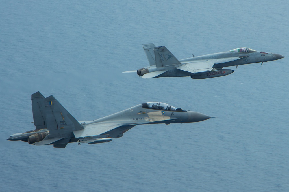 An F/A-18E Super Hornet and a Royal Malaysian Air Force SU-30MKM/Flanker H, fly in formation above the aircraft carrier USS Carl Vinson (CVN 70) during a bi-lateral exercise aimed at developing and enhancing security ties and partnerships with the Malaysian Royal Military. The Carl Vinson Strike Group is deployed to the U.S. 7th Fleet area of operations supporting security and stability in the Indo-Asia-Pacific region. (U.S. Navy photo by Lieutenant Jonathan Pfaff/Released)