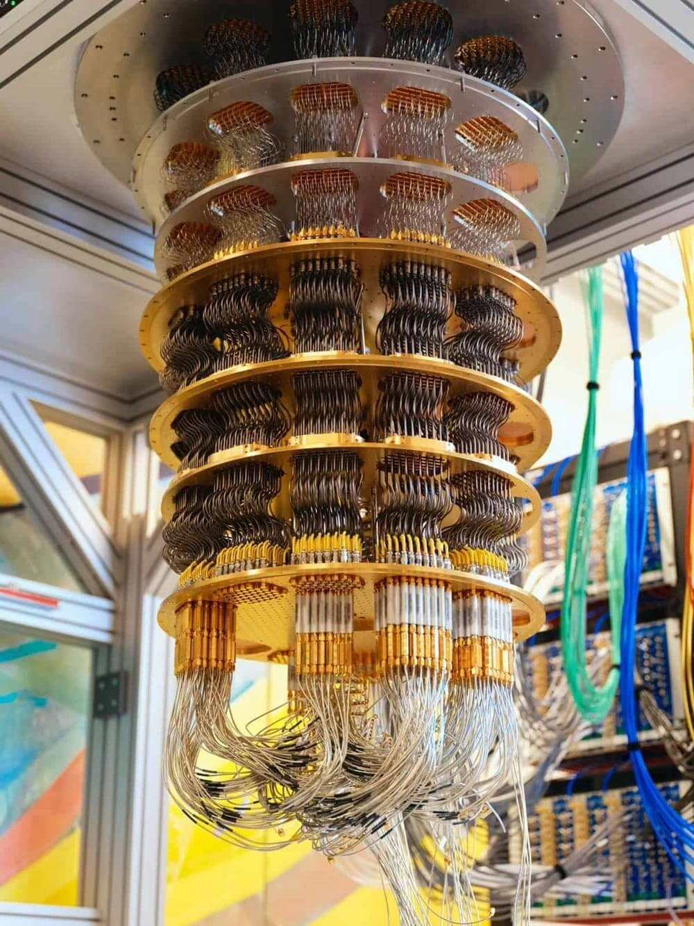This image shows the inside of gold-plated nested cylindrical stages (the mixing chamber and wiring harness) of a dilution refrigerator that holds and cools a superconducting quantum processor, such as Google’s Willow quantum system.